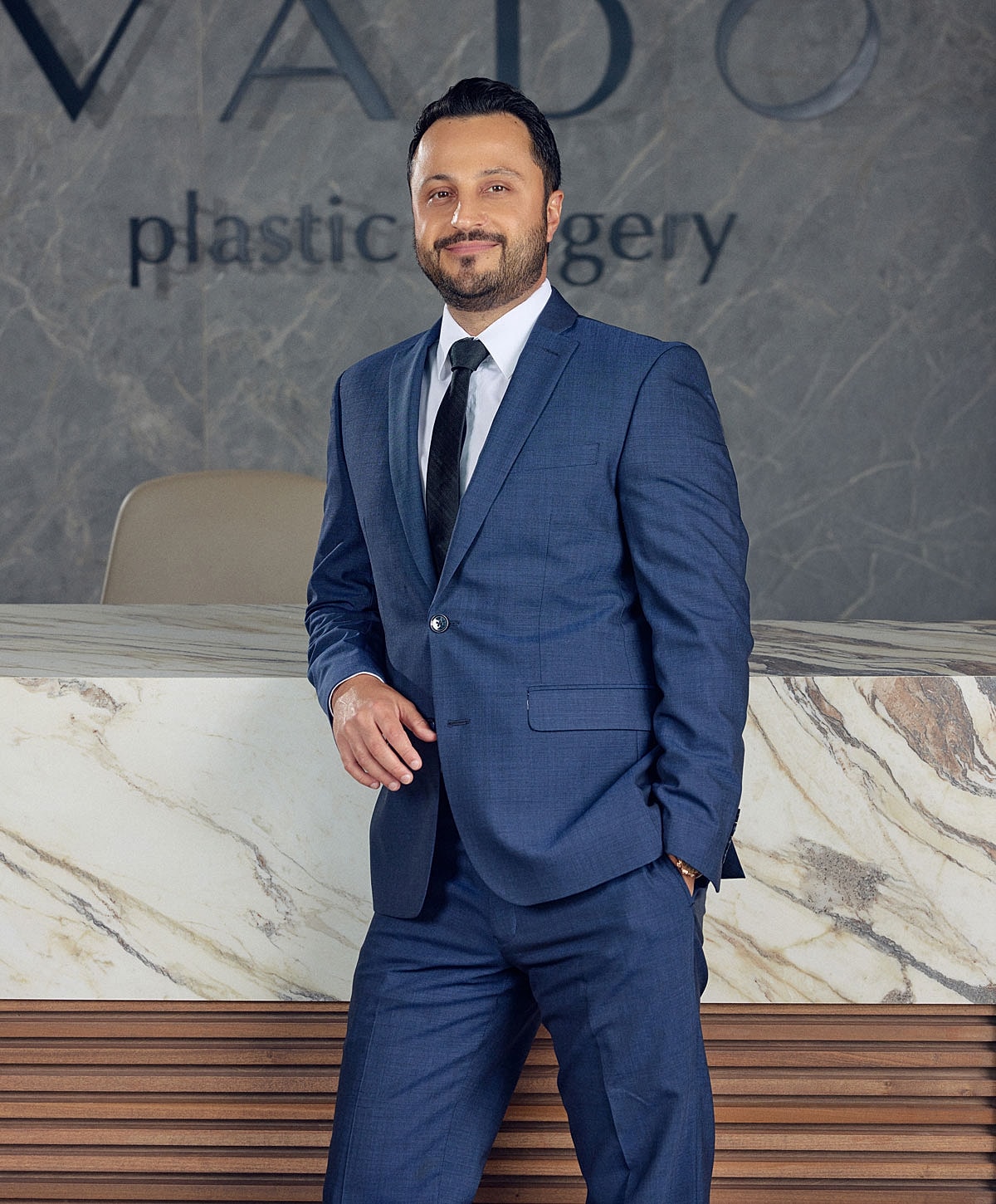 Man in suit at plastic surgery office reception.