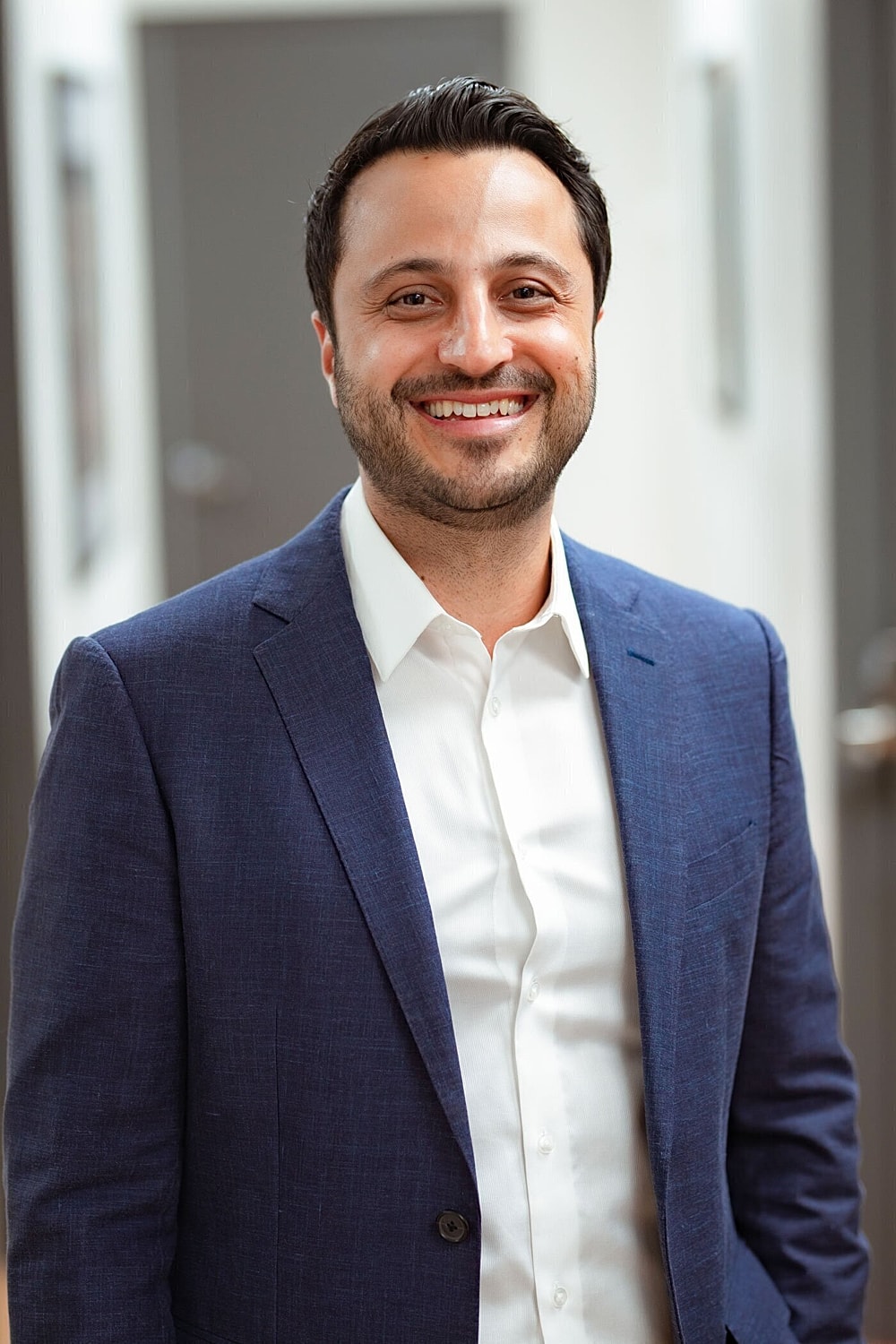 Smiling man in a suit indoors.
