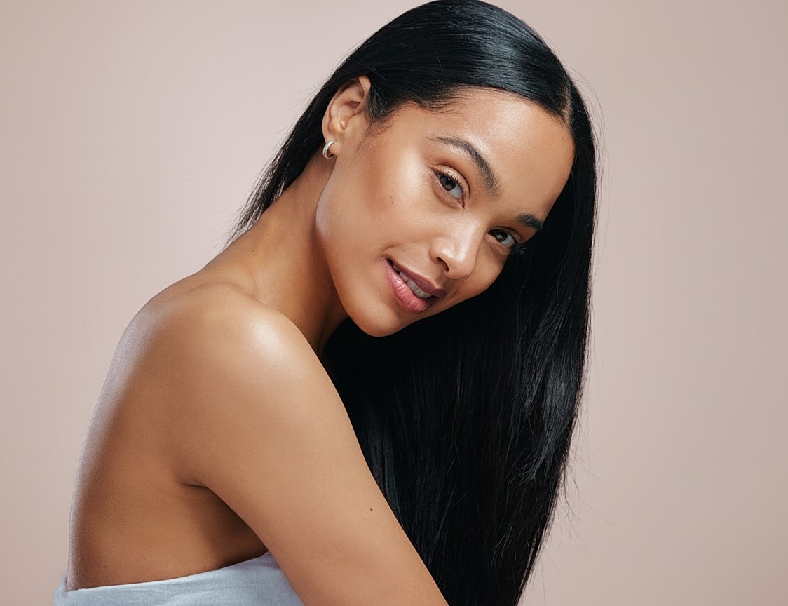 Woman with long hair against a neutral background.