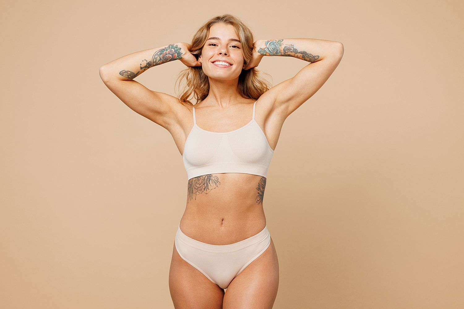 Smiling woman in stylish underwear against beige background.