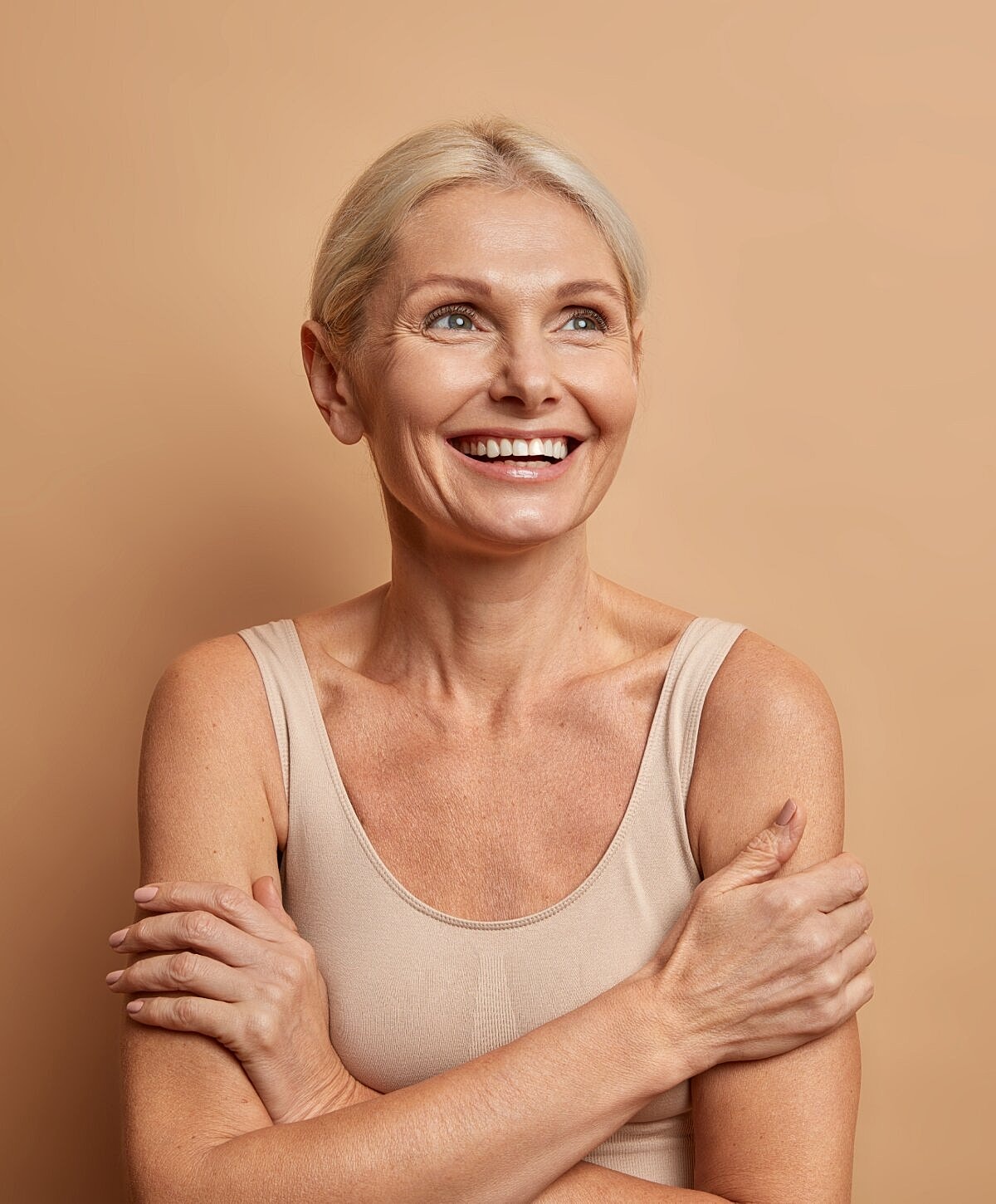Smiling middle-aged woman with light background.