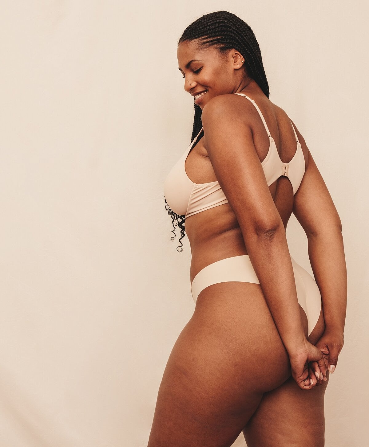 Smiling woman in nude bikini, side profile.