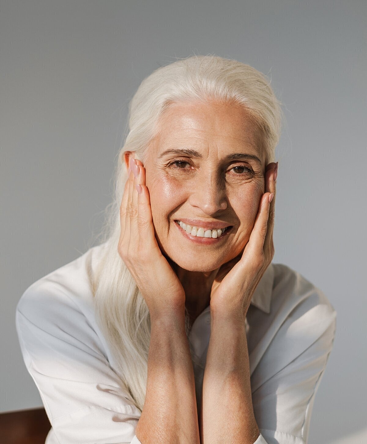 Smiling elderly woman with gray hair.