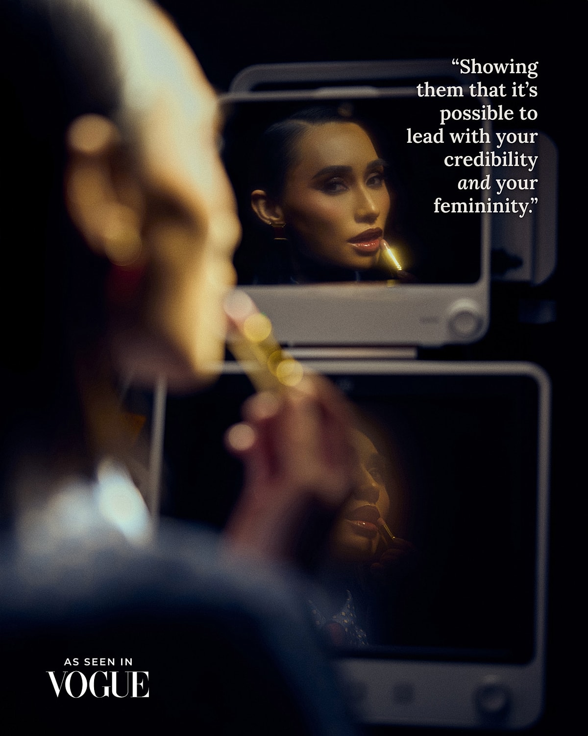 Model applying lipstick, reflection in mirror
