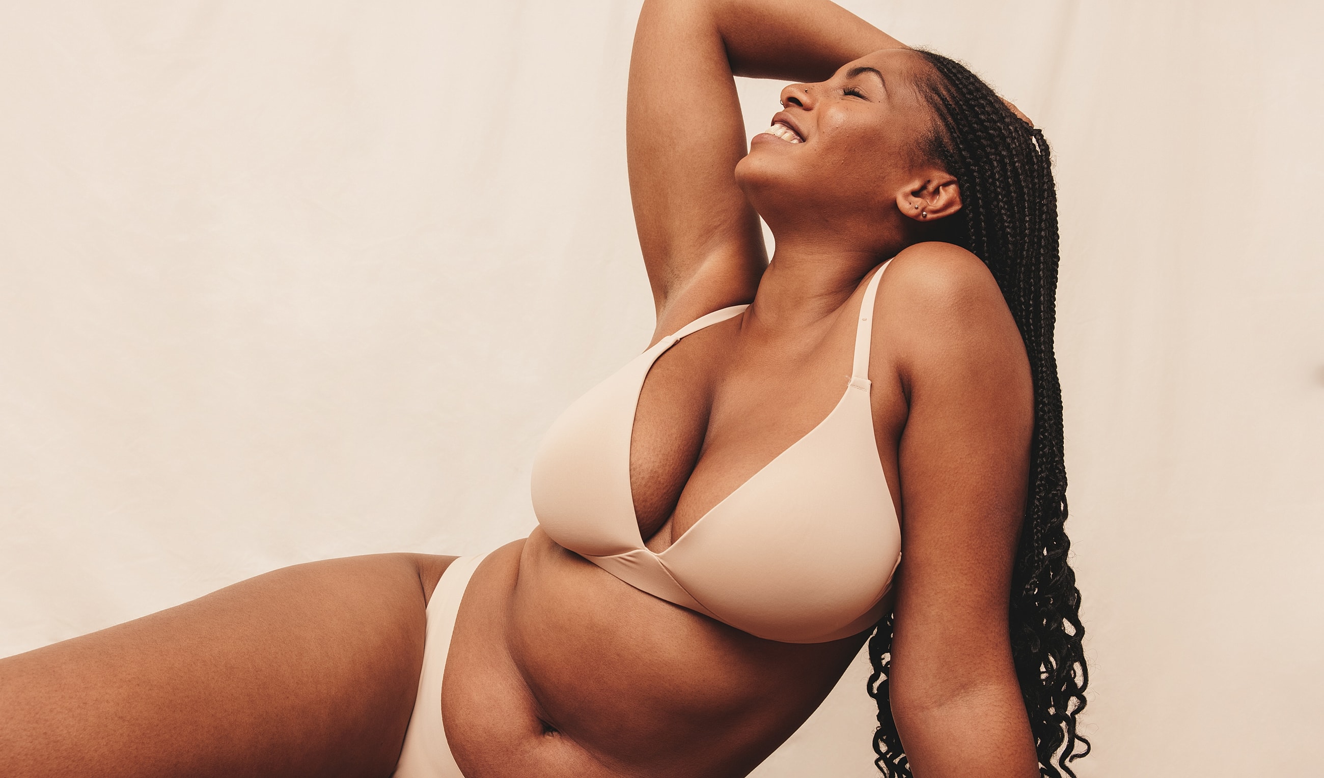 Model posing confidently in beige lingerie.