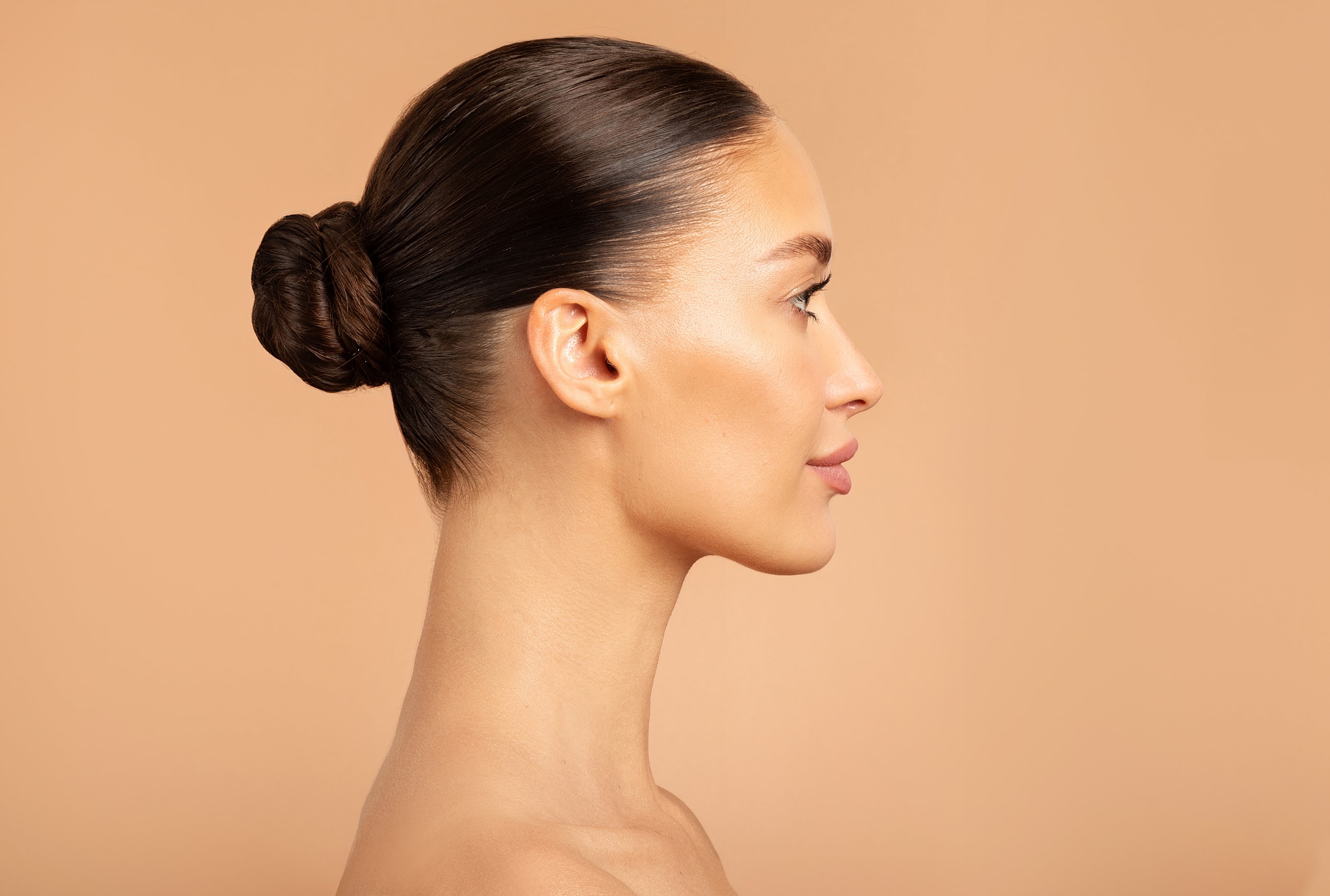 Profile of a woman with a sleek bun hairstyle.