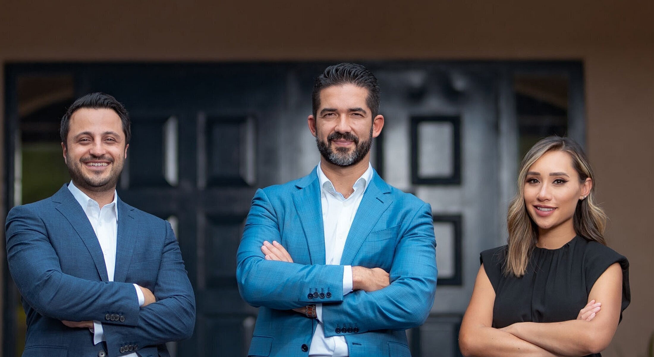 Three professionals standing confidently outdoors.