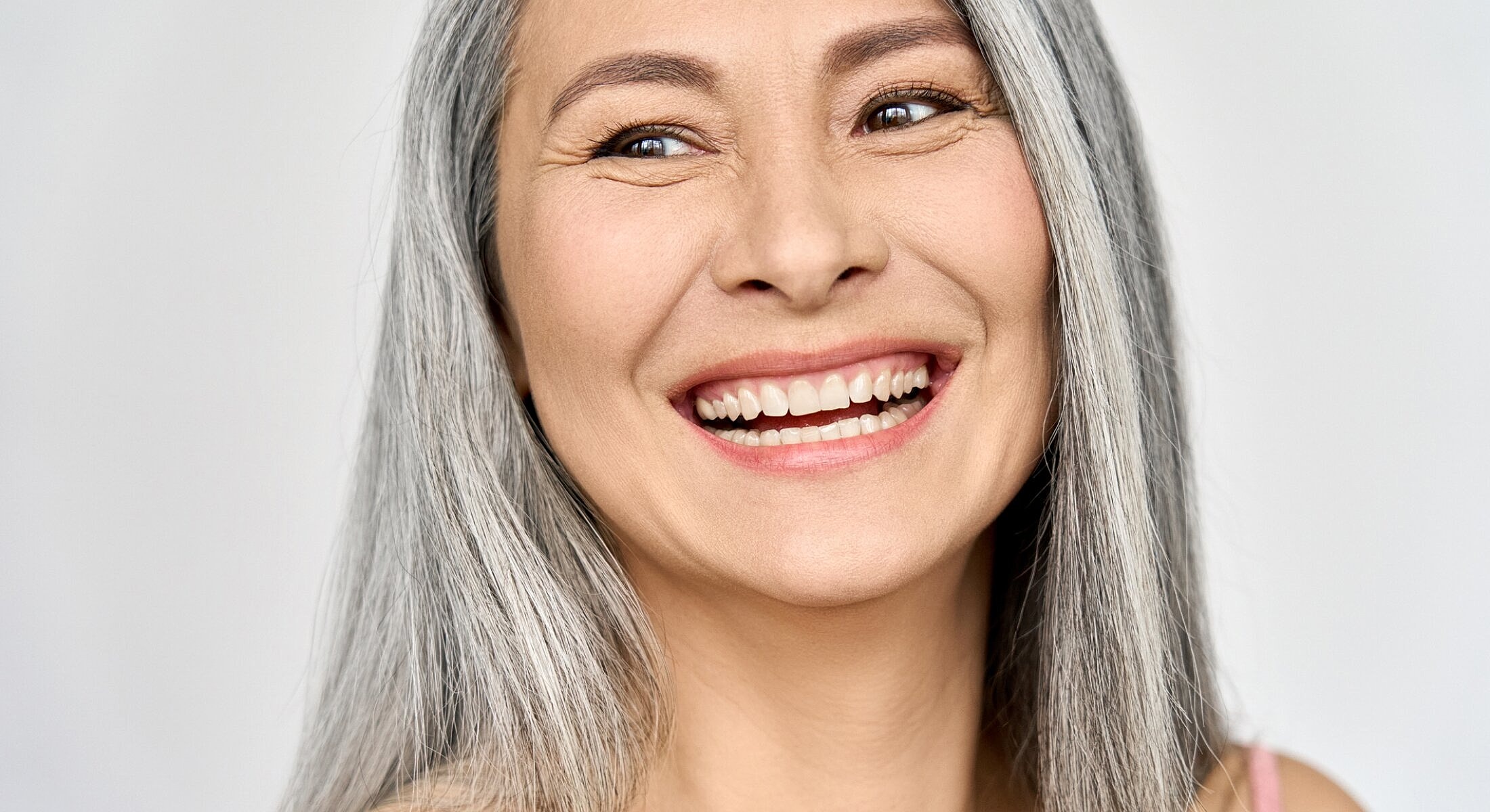 Smiling woman with long gray hair.