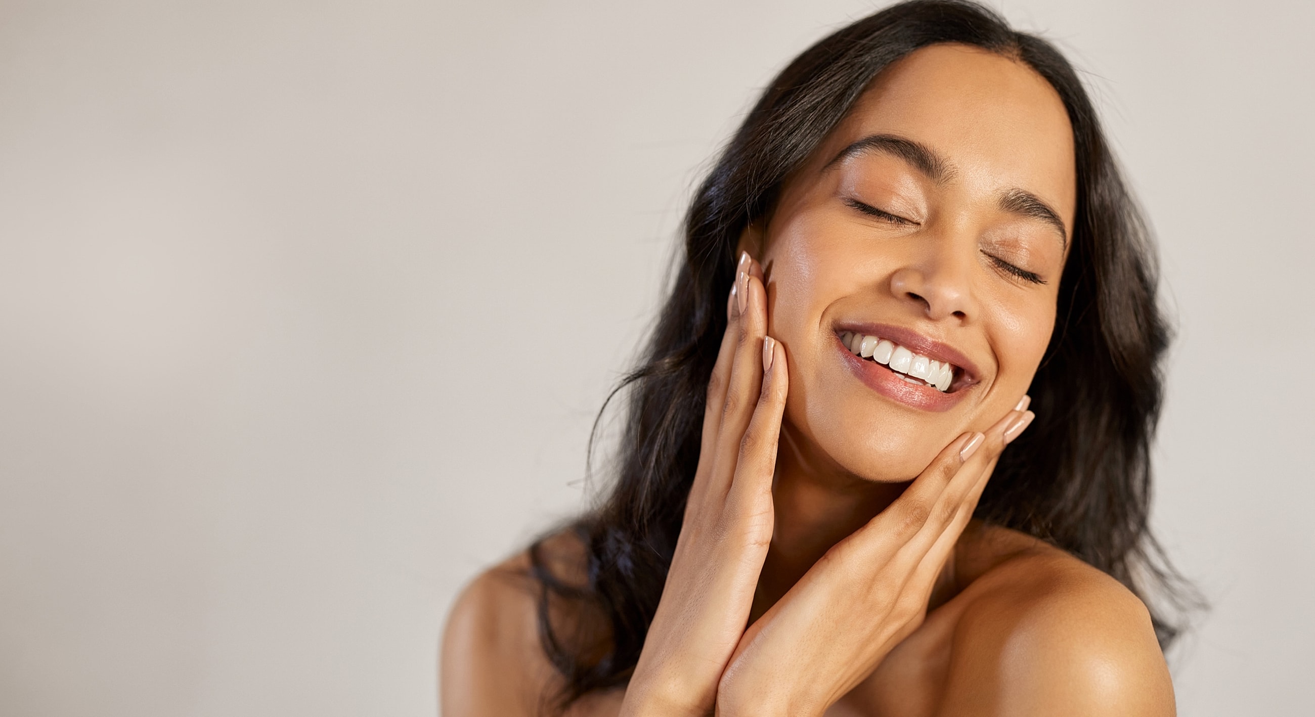 Smiling woman with glowing skin and joyful expression.